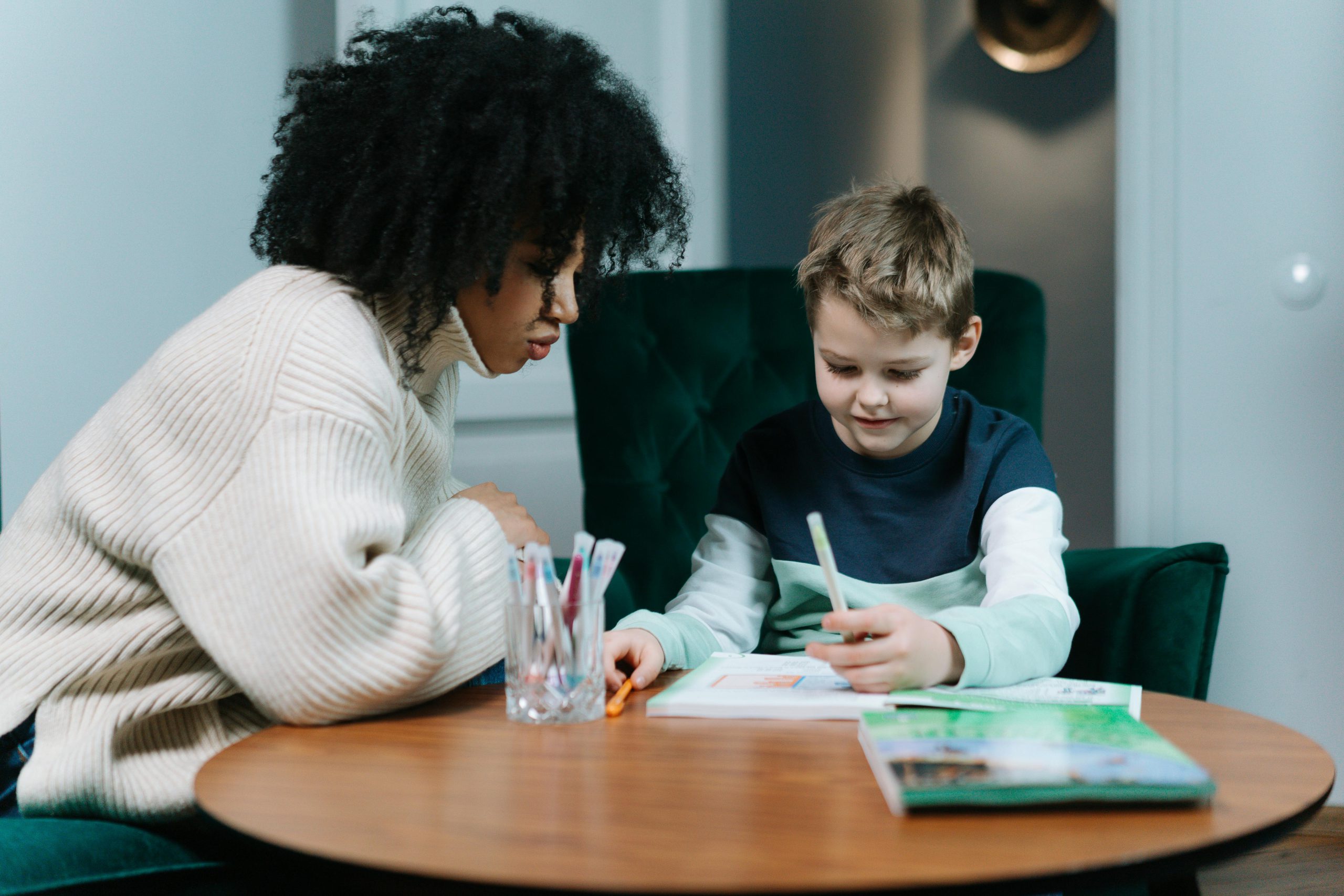 A young boy and an elderly lady looking at a book, illustrating our home lessons