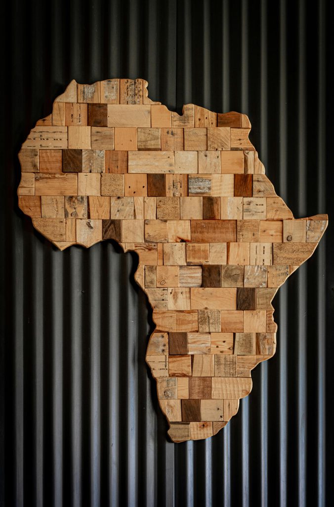 A scrabbled Africa map on a black panel wall